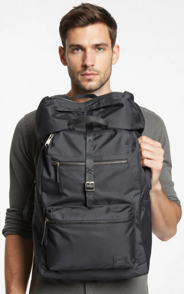 A French male model with a Zip   and   buckle backpack, wearing a shirt, against a white background, in a front   facing close   up